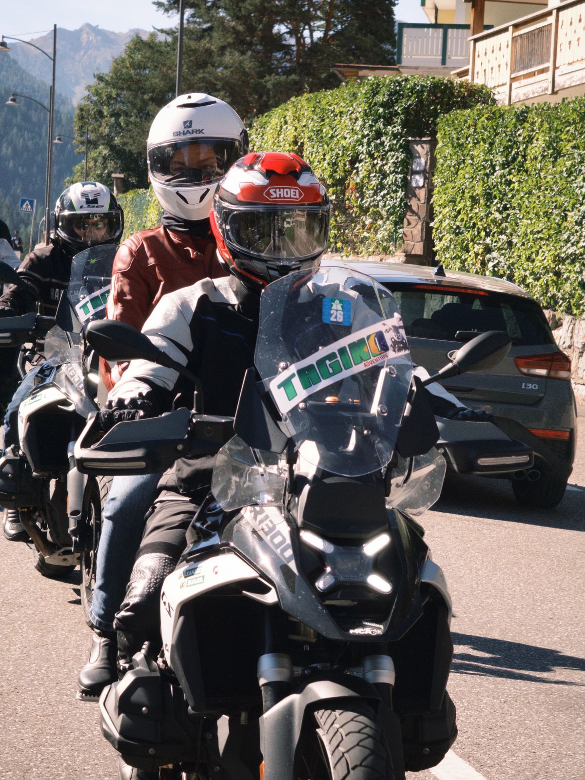 Piloto e garupa em moto adventure na estrada
