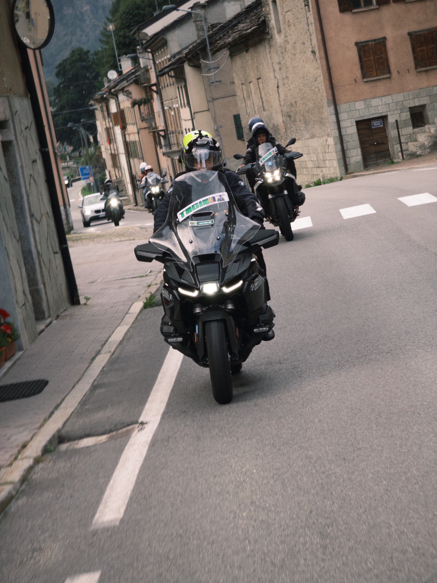 Motos passando por uma rua de vila de montanha