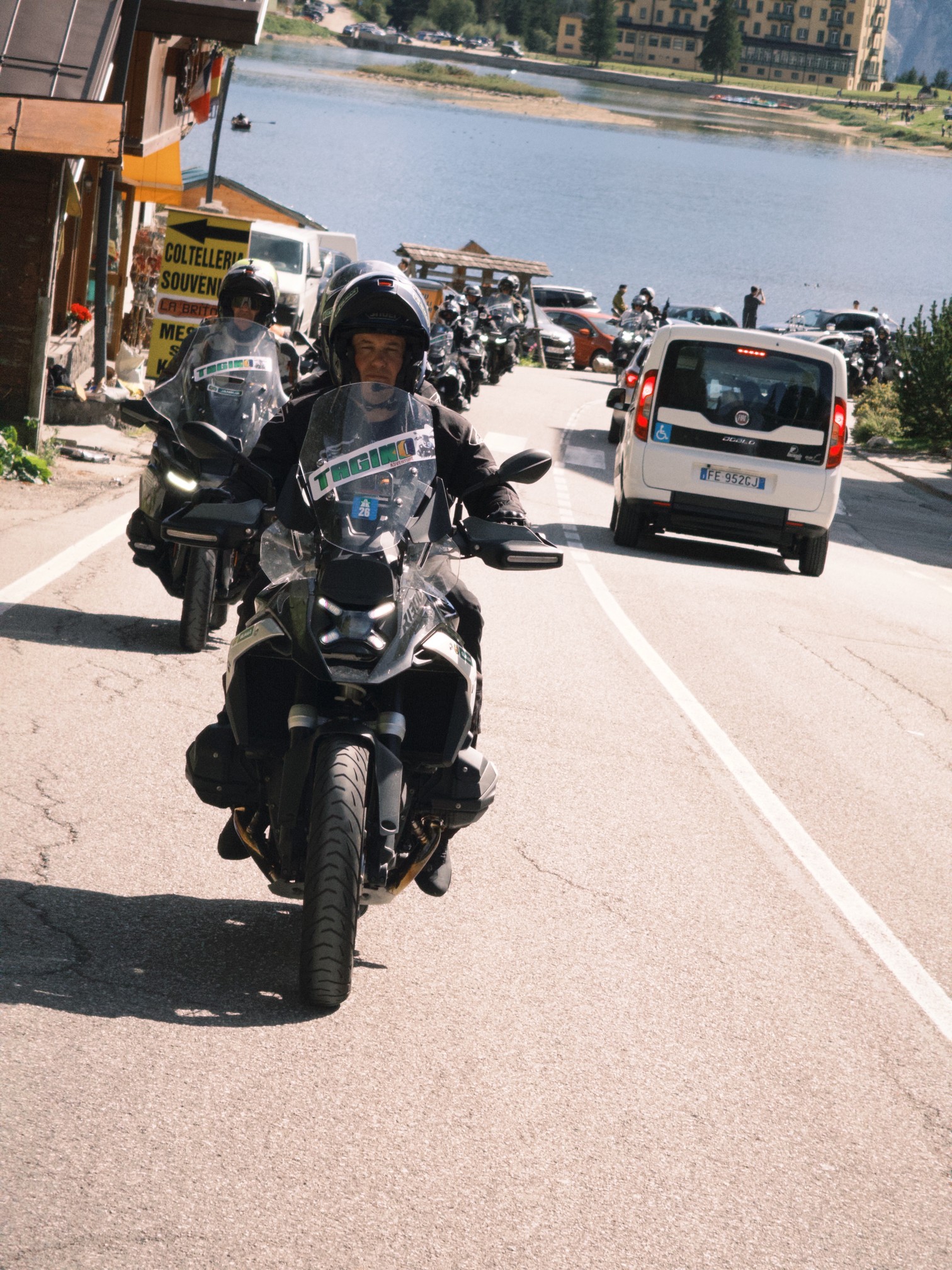 Piloto chegando pela estrada à beira de um lago nos Alpes