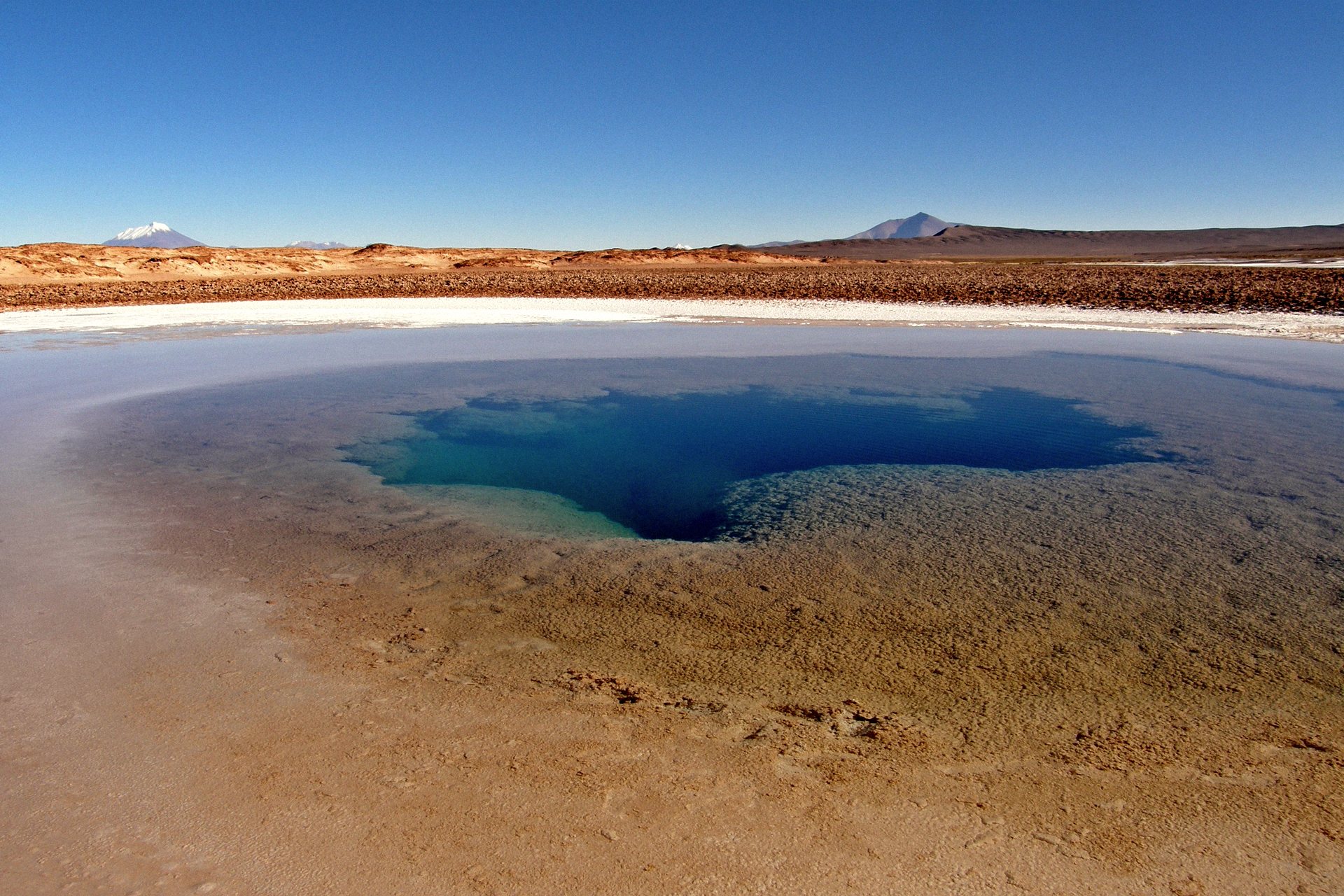 Olho de água azul no salar perto de Tolar Grande