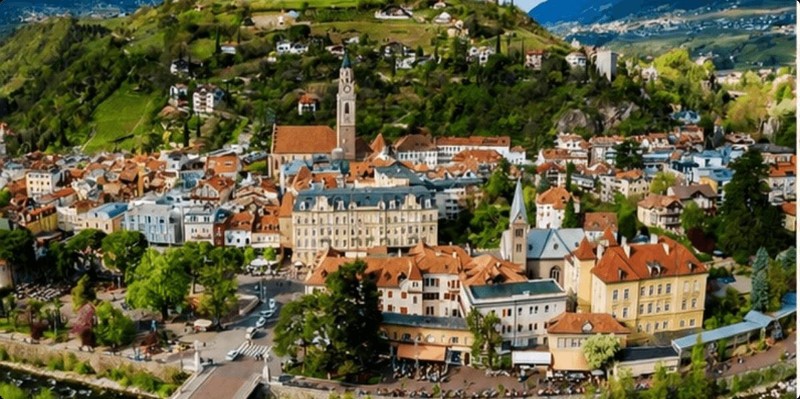 Cidade alpina com torres de igreja entre montanhas verdes
