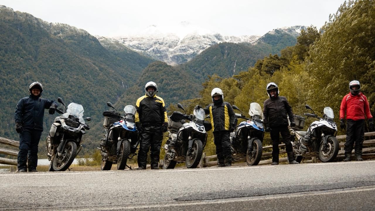 Grupo com as motos diante de montanhas nevadas