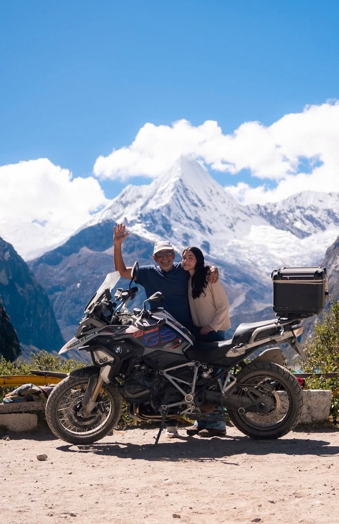 Casal em moto BMW GS diante de montanha nevada da Cordilheira Branca