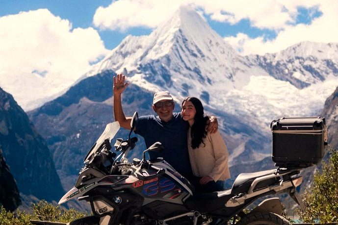 Casal em moto BMW GS diante de montanha nevada da Cordilheira Branca