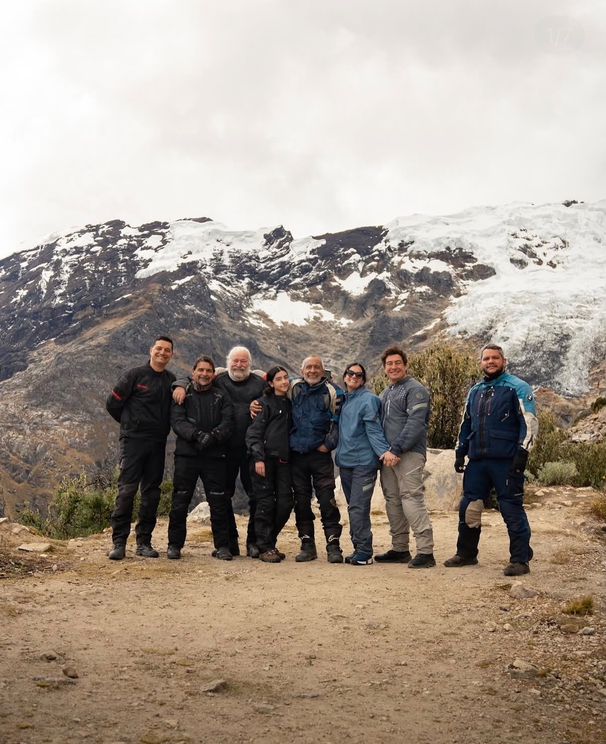 Grupo de pilotos em pé diante de montanhas com neve