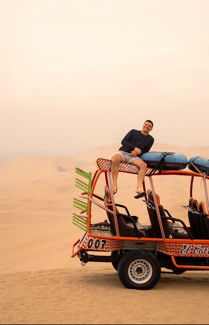 Buggy nas dunas de Huacachina com um passageiro sentado no teto
